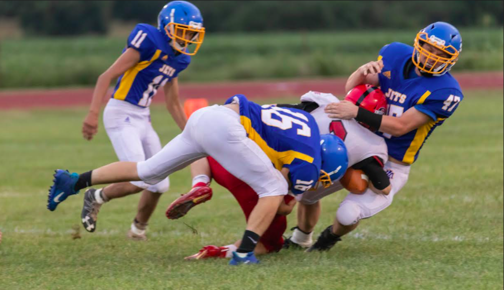 NOT SO FAST – Altoona-Midway defenders Jimmy Willard (16) and Dayton Marsh (47) combine to bring down an Oswego ball carrier as Dustin Reeves (11) races in to help. Oswego won the Three Rivers League eight-man contest 48-0. (Photo by Debra Meigs)