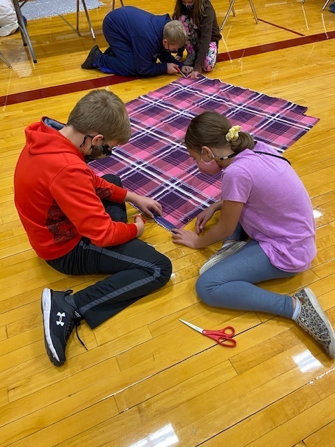 Students working together to measure and cut their homemade blankets