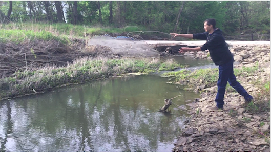 Dustin tosses a throw net over the riverbank.