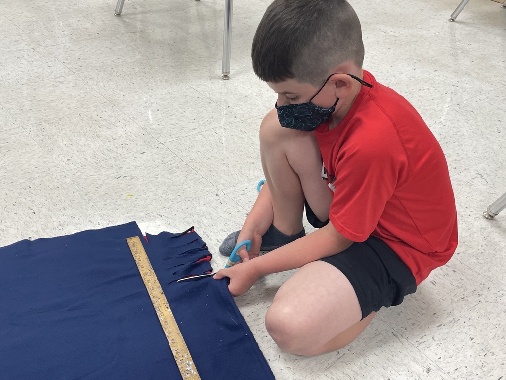 boy cutting blanket on floor