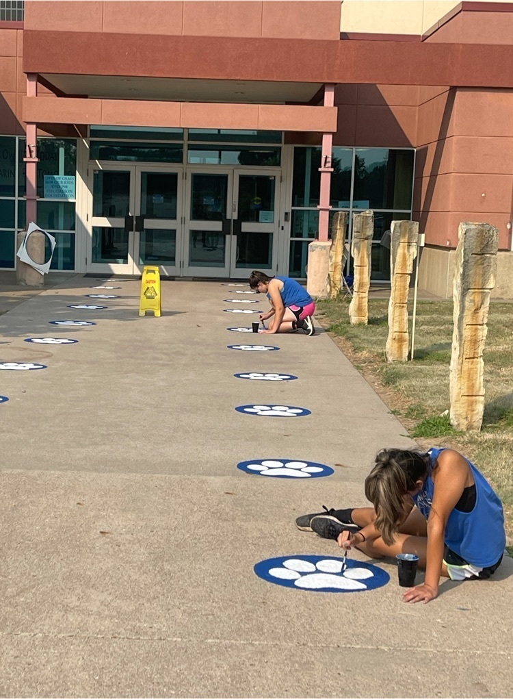 Tana and Yazmin work on repainting paw prints. 