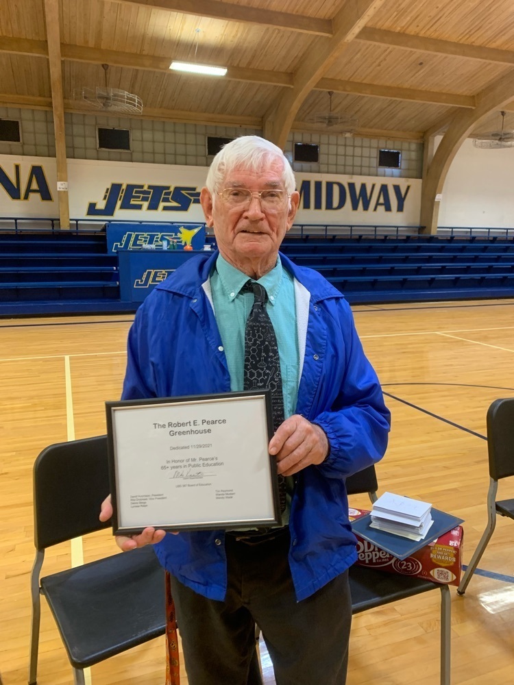 Mr. Pearce holds a plaque.