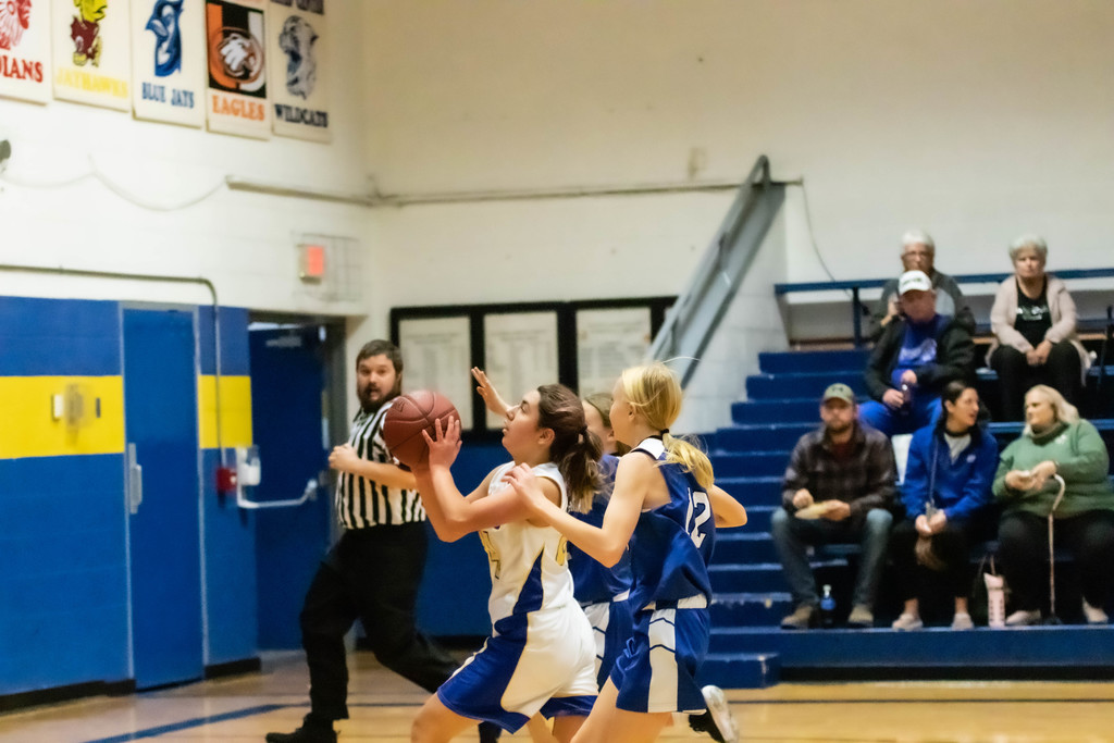 Girl shoots basketball.