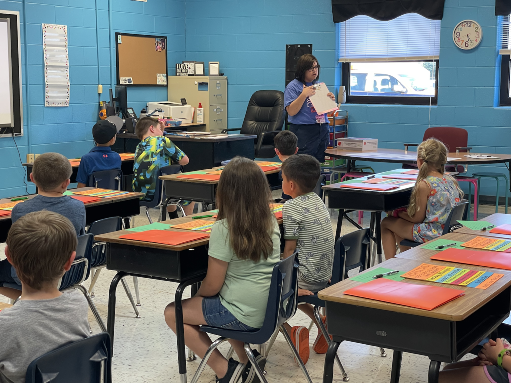 teacher at front of classroom talking to parents at desks