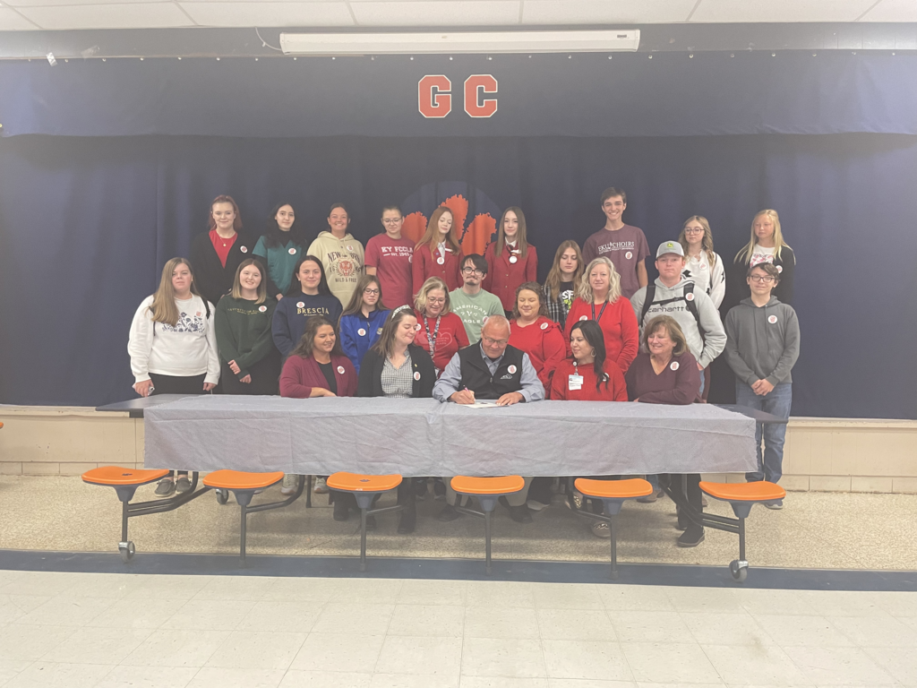 Students with county judge signing proclamation