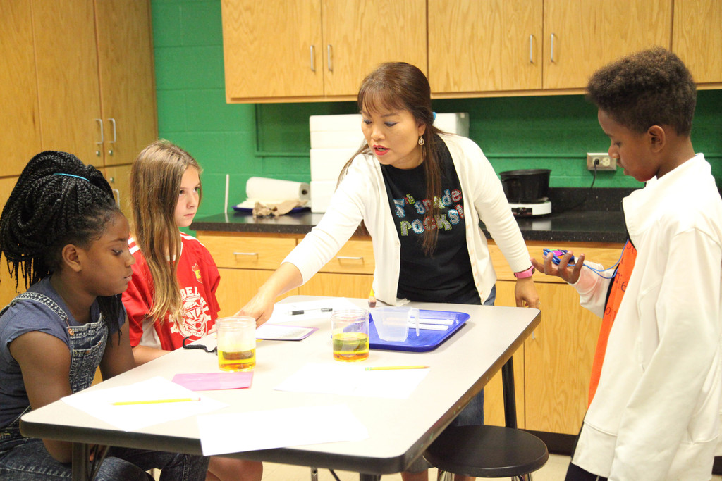 Ms. Rippeto helping students with science experiment