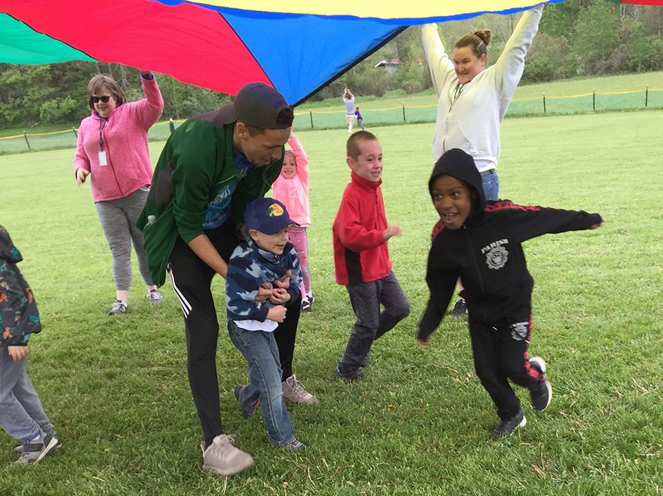 students running under parachute