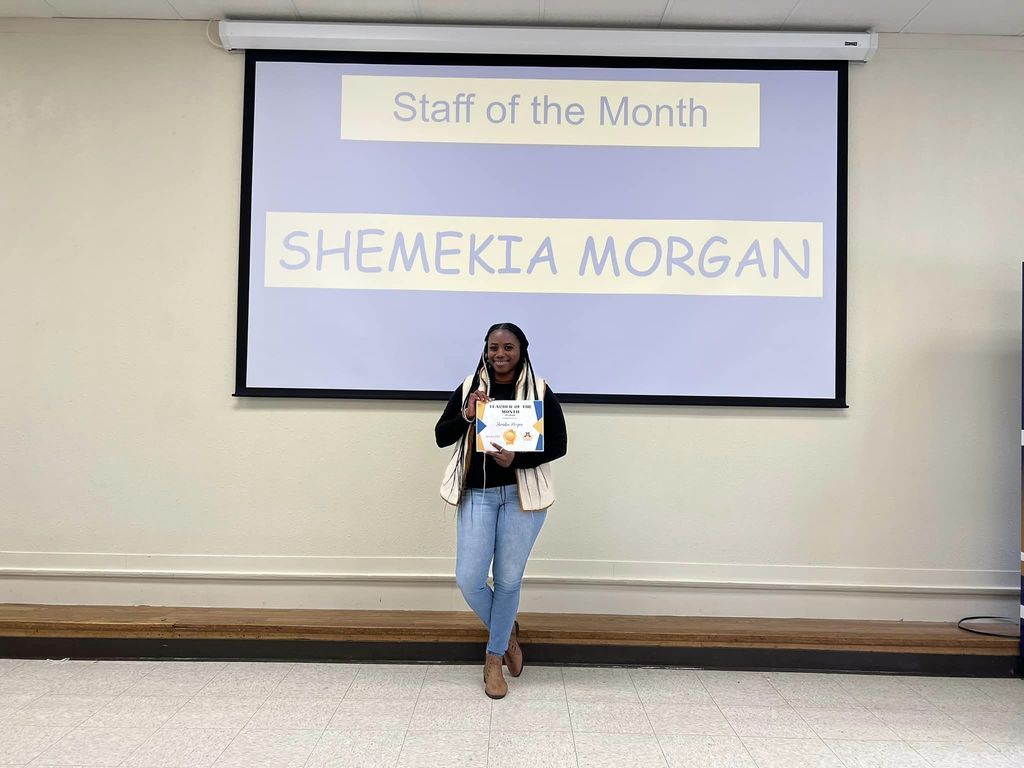 teacher standing with certificate