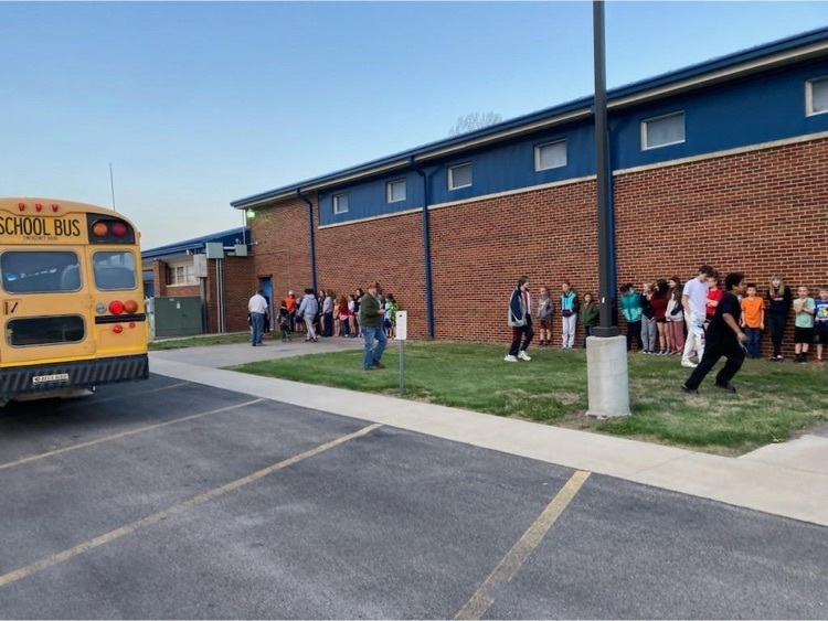 students stand outside after bus evacuation drill