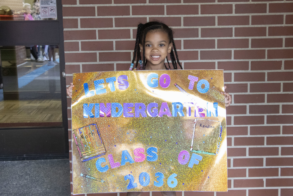 kindergartner holding a sign ready for school to start