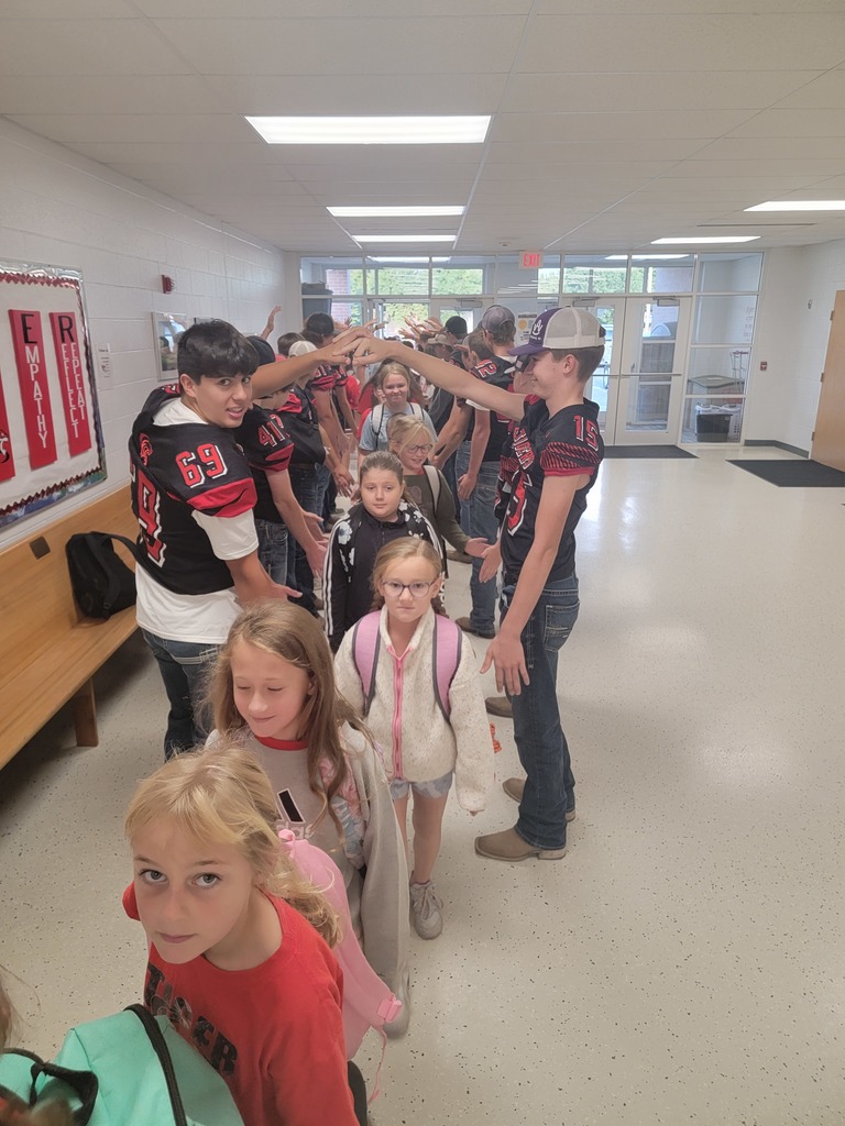 high school students greeting elementary students