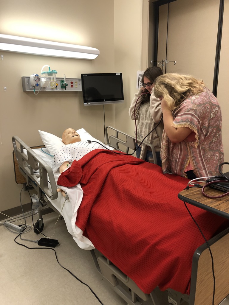 Students check vitals on a mannequin