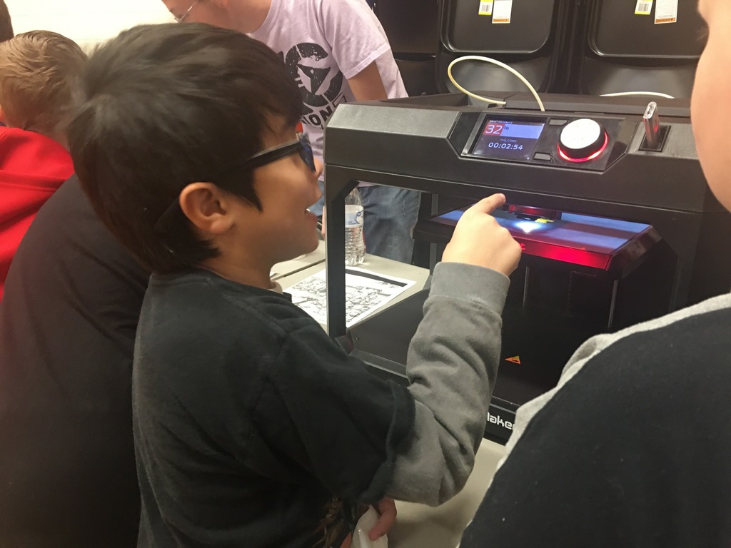 boy pointing to 3d printer