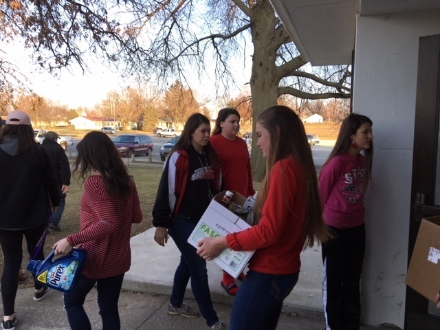 Student Council members helping families load donations.