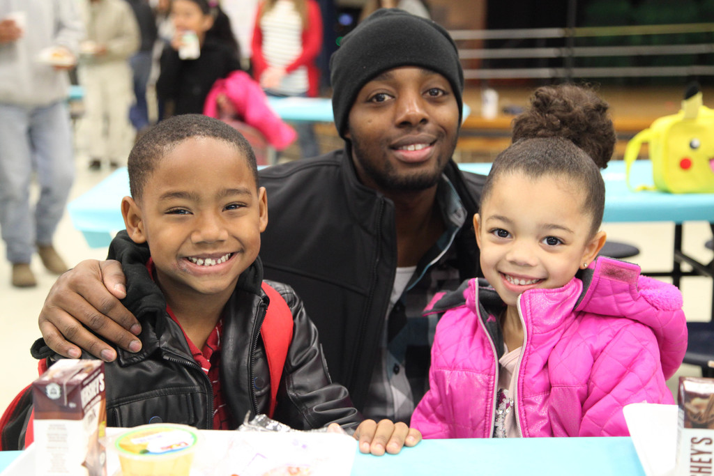 Dad posing with his children at Donuts for Dads