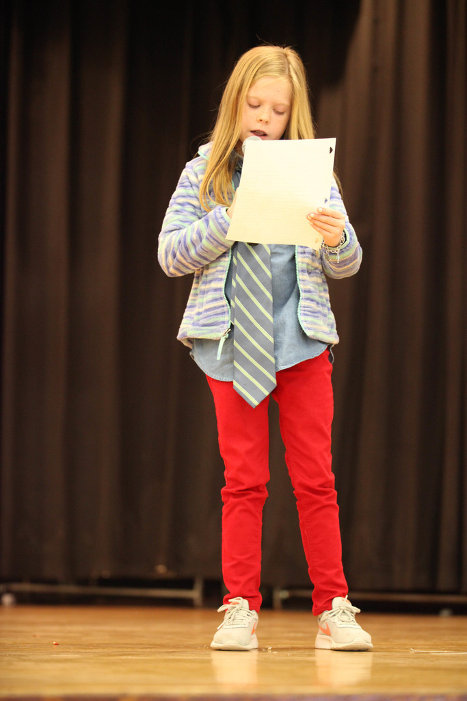 student reading a script from stage